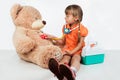 Baby is playing doctor, treats a bear Royalty Free Stock Photo