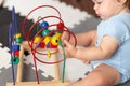 Baby playing with educational toy in nursery. Learning colorful wooden toy.developing toy. The labyrinth of wooden beads.geometric Royalty Free Stock Photo