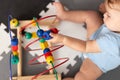 Baby playing with educational toy in nursery. Learning colorful wooden toy.developing toy. The labyrinth of wooden beads.geometric Royalty Free Stock Photo