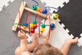 Baby playing with educational toy in nursery. Learning colorful wooden toy.developing toy. The labyrinth of wooden beads.geometric Royalty Free Stock Photo