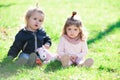 Baby playing in green grass. Child having fun on family picnic in summer garden. Brother and sister play together in a Royalty Free Stock Photo