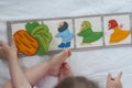 Baby playing with handmade textile book. Child pointing with her finger at a book with funny felt toys. Early development. Royalty Free Stock Photo