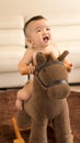 Baby playing hobbyhorse Royalty Free Stock Photo