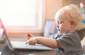 Baby playing with laptop computer .