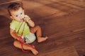 Baby playing with a medical stethoscope on the floor of his house, pediatrics concept