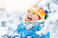 Baby playing with snow in winter. Child in snowy park. Royalty Free Stock Photo