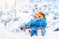 Baby playing with snow in winter. Child in snowy park. Royalty Free Stock Photo