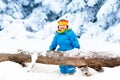 Baby playing with snow in winter. Child in snowy park. Royalty Free Stock Photo