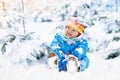 Baby playing with snow in winter. Child in snowy park. Royalty Free Stock Photo