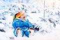 Baby playing with snow in winter. Child in snowy park. Royalty Free Stock Photo