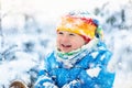 Baby playing with snow in winter. Child in snowy park. Royalty Free Stock Photo