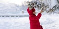 Baby playing with snow in winter. Little toddler boy in red jacket and Xmas reindeer knitted hat catching snowflakes in Royalty Free Stock Photo