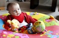 Baby playing with soft toy in playpen Royalty Free Stock Photo