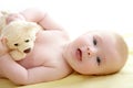 Baby playing teddy bear laying on bed