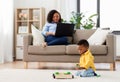 Baby playing toy blocks and mother using laptop Royalty Free Stock Photo