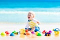 Baby playing on tropical beach digging in sand Royalty Free Stock Photo