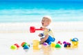 Baby playing on tropical beach digging in sand Royalty Free Stock Photo