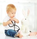 Baby plays in doctor toy bunny rabbit and stethoscope Royalty Free Stock Photo