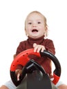 Baby plays a driving game console, isolated on