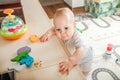 Baby plays on floor with educational toys, rattles and teething toys. Crawling babies at 8 months