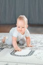 Baby plays on floor with educational toys, rattles and teething toys. Crawling babies at 8 months