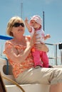 Baby points at sail while sitting on a sailboat Royalty Free Stock Photo