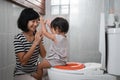 baby pup clapping jokingly with his mother against the background of the toilet Royalty Free Stock Photo