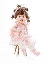 Baby Porcelain Doll sitting on a Wooden Chair Royalty Free Stock Photo