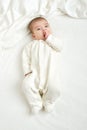 Baby portait lie on white towel in bed, yellow toned