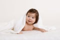 Baby portrait in bed under white towel at studio, yellow toned Royalty Free Stock Photo