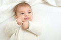 Baby portrait lie on white towel in bed, yellow toned Royalty Free Stock Photo