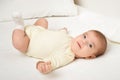 Baby portrait lie on white towel in bed, yellow toned Royalty Free Stock Photo