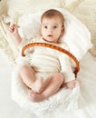 Baby portrait lie on white towel in bed, yellow toned Royalty Free Stock Photo