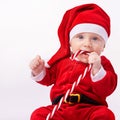 Baby, portrait and studio with santa costume for first Christmas holiday, candy cane and white background. Boy toddler Royalty Free Stock Photo