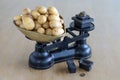 Baby potatoes on a retro scales on the wooden desk