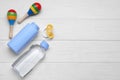 Baby powder, oil, pacifier and toys on white wooden table, flat lay. Space for text Royalty Free Stock Photo