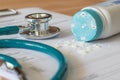 Baby powder product with talc mineral spilling over diagnosis record paper on doctor`s pad with stethoscope in teal color