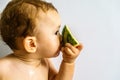 Baby in profile eating a watermelon drooling and getting dirty with the sticky juice of the fruit