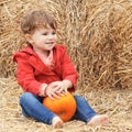 Baby with pumpkins on a farm