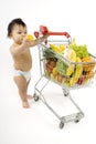 Baby pushes a shopping cart Royalty Free Stock Photo