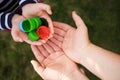 Baby puts plastic lids in mother`s hands. parent and his child collect cover. e.