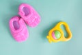 Baby rattle and booties on green background Royalty Free Stock Photo