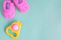 Baby rattle and booties on green background Royalty Free Stock Photo