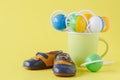 Baby rattle and booties on yellow background Royalty Free Stock Photo