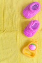 Baby rattle and booties on yellow background Royalty Free Stock Photo