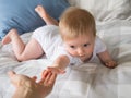 Baby reaching out for mother's hand