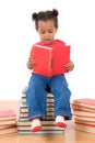 Baby reading sitting on a pile of books