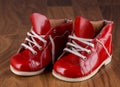 Baby red shoes on a wooden floor. Royalty Free Stock Photo