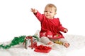 Baby in red velvet Christmas dress reaches up Royalty Free Stock Photo