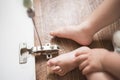 Baby repairs the cabinet door with a screwdriver